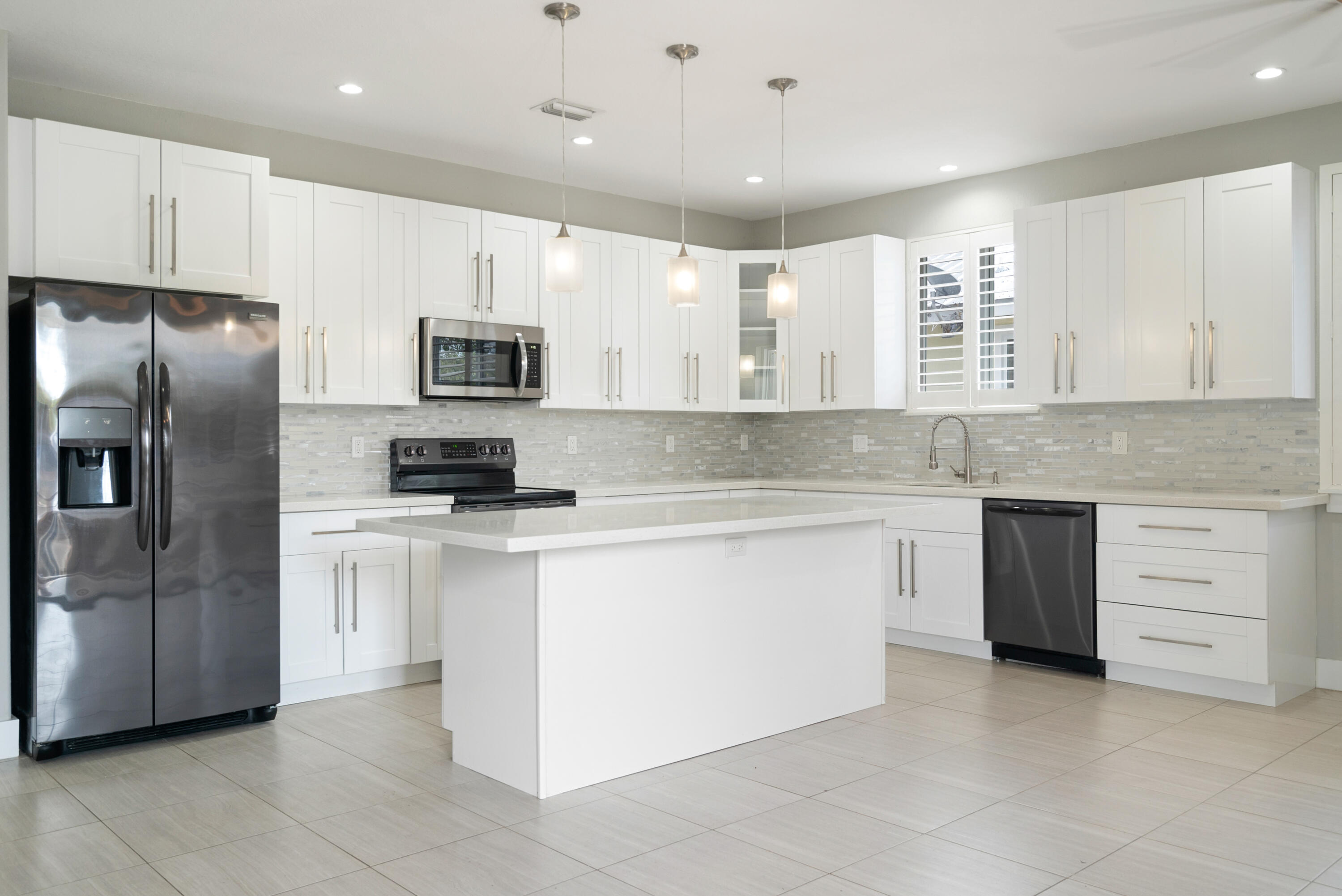 582 Boyd Drive Key Largo, FL 33037 - Photo 2 of 36 a kitchen with stainless steel appliances granite countertop a stove a sink and a refrigerator