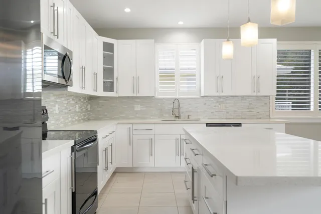 a kitchen with cabinets appliances a sink and a window