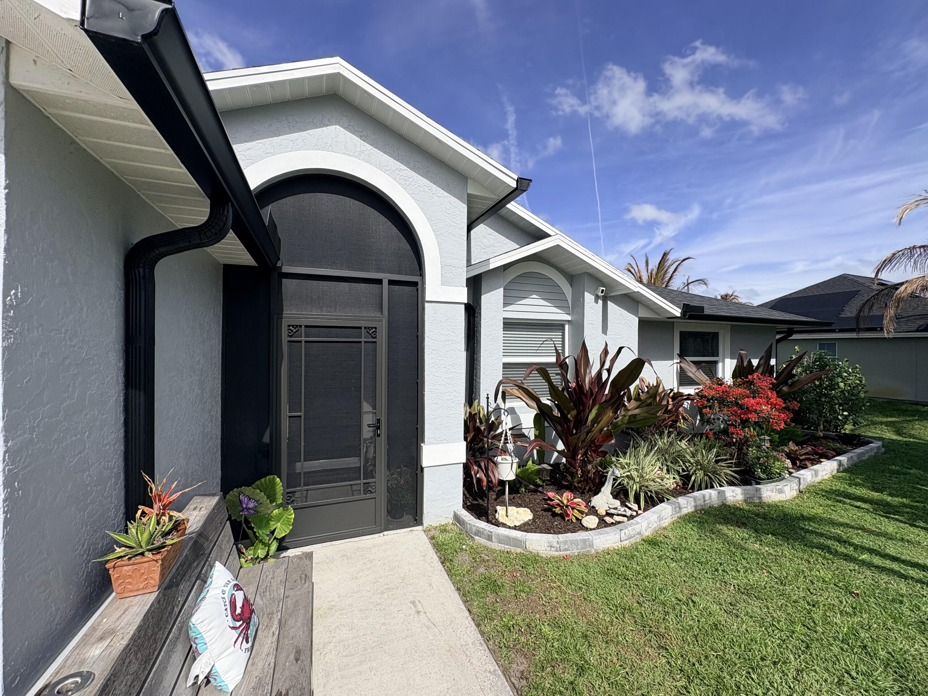 462 Southeast Cork Road Port St. Lucie, FL 34984 - Photo 13 of 57 a front view of a house with a garden