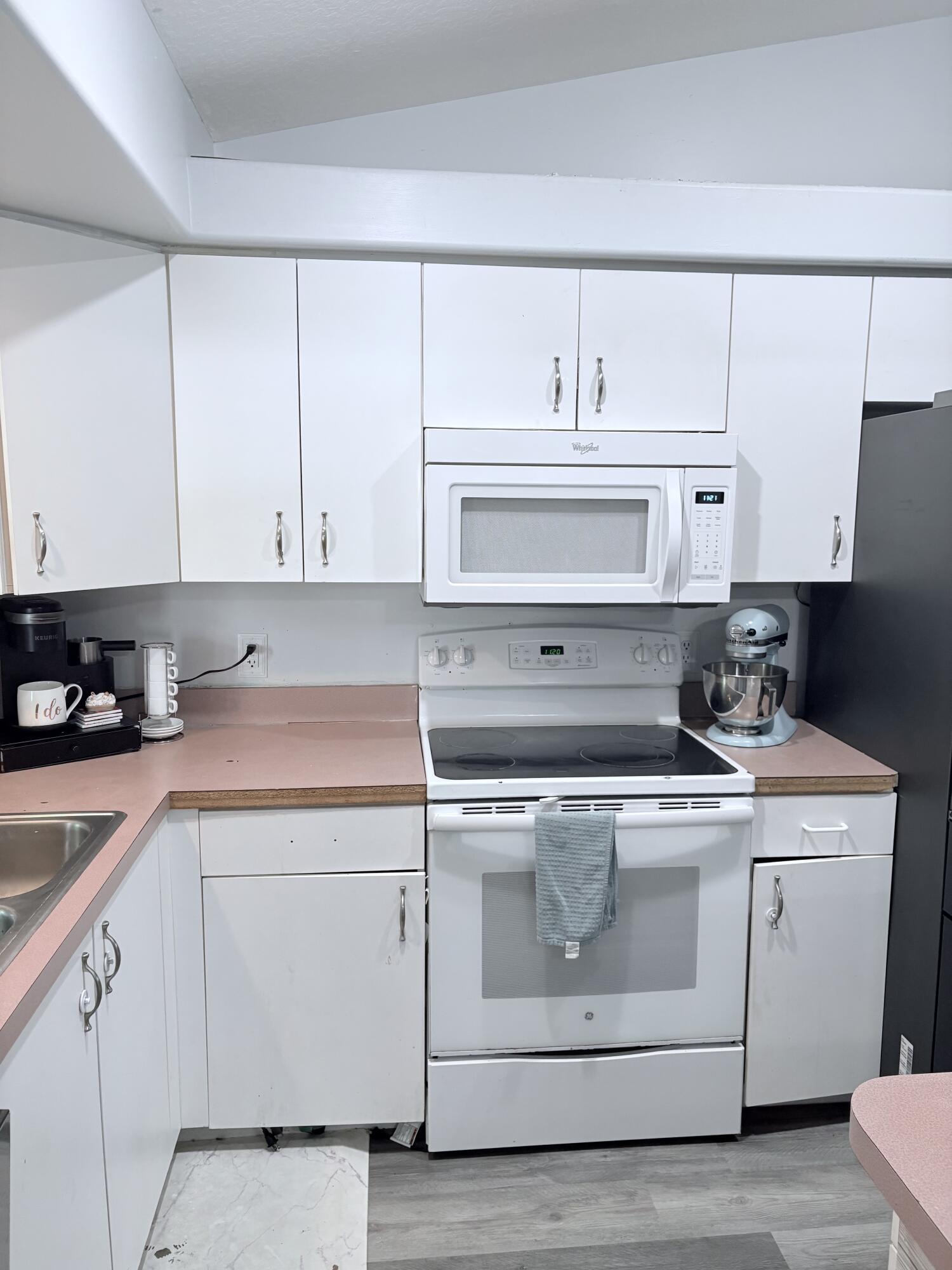 462 Southeast Cork Road Port St. Lucie, FL 34984 - Photo 19 of 57 a kitchen with white cabinets and white appliances