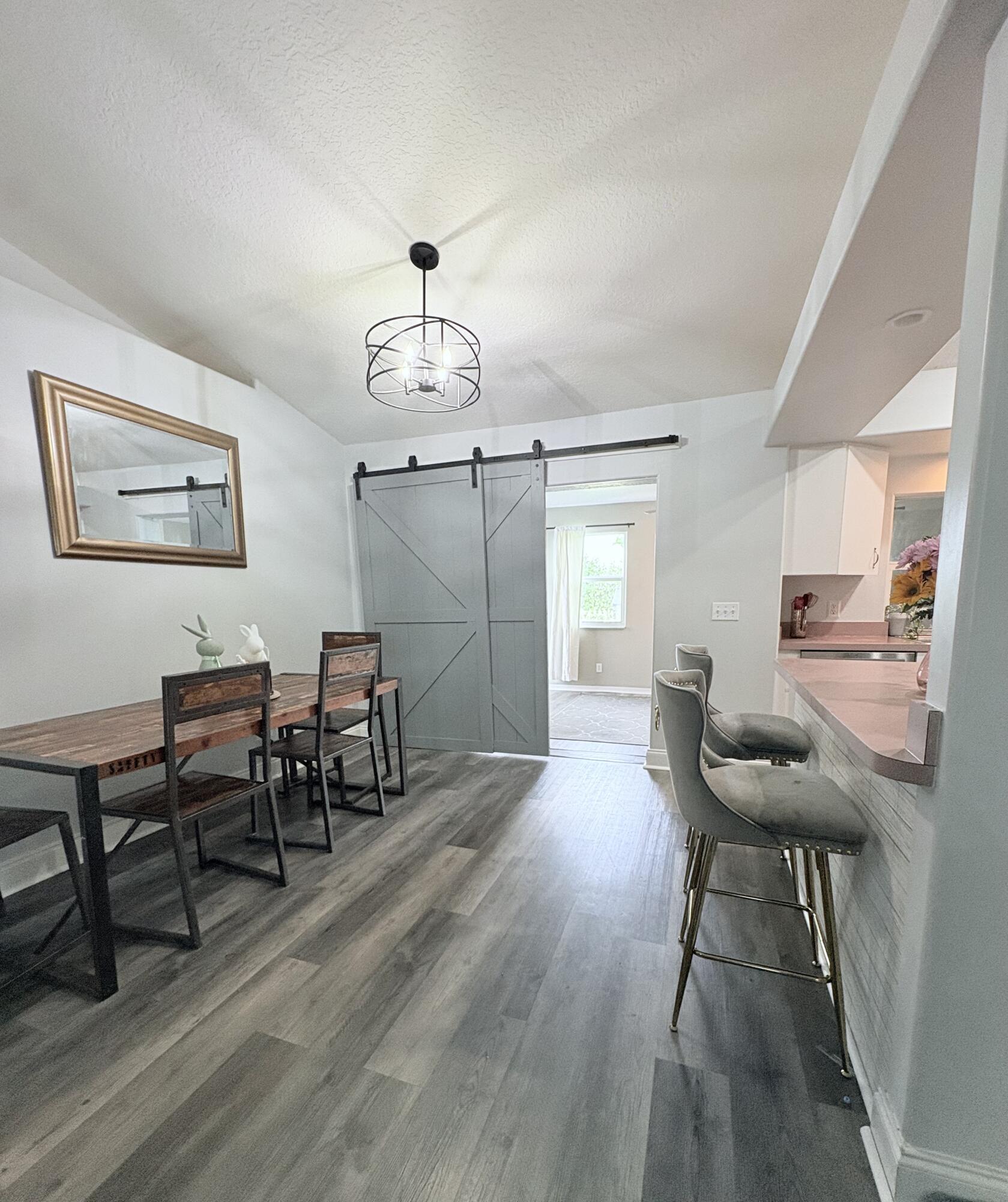 462 Southeast Cork Road Port St. Lucie, FL 34984 - Photo 26 of 57 a view of a dining room with furniture and wooden floor