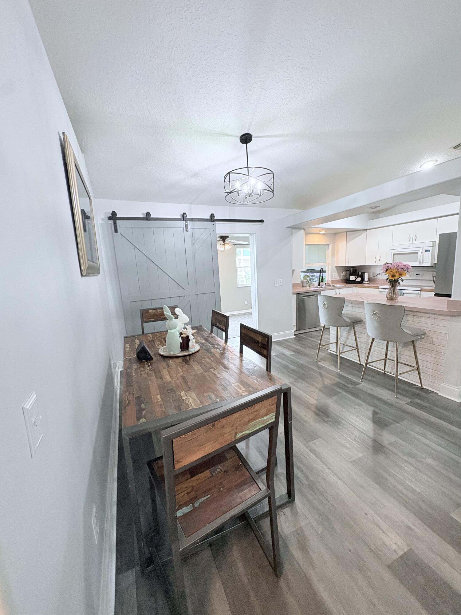 462 Southeast Cork Road Port St. Lucie, FL 34984 - Photo 30 of 57 a view of a dining room with furniture and wooden floor