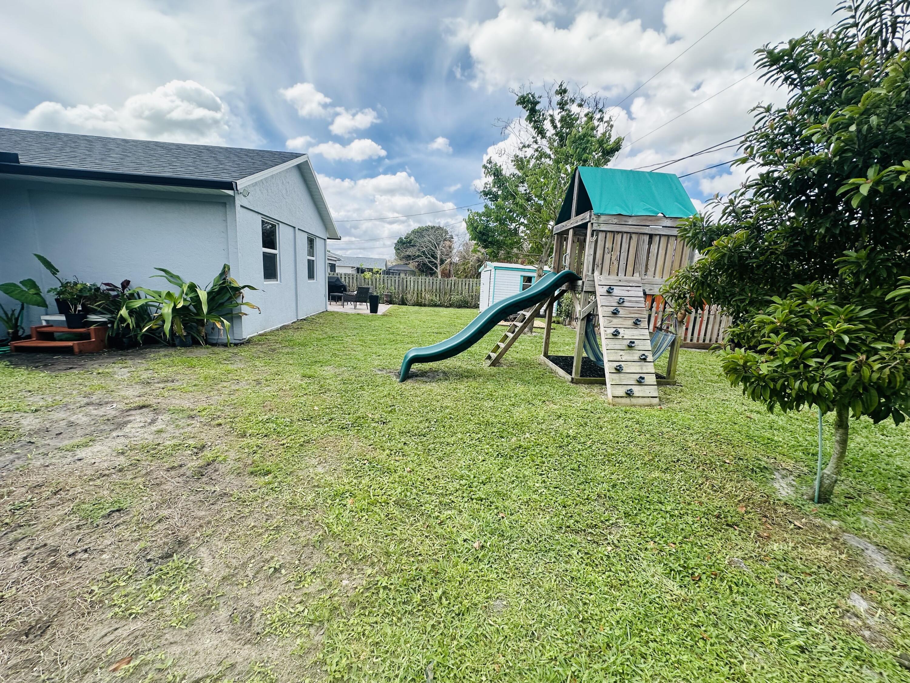 462 Southeast Cork Road Port St. Lucie, FL 34984 - Photo 33 of 57 a view of a garden with a slide