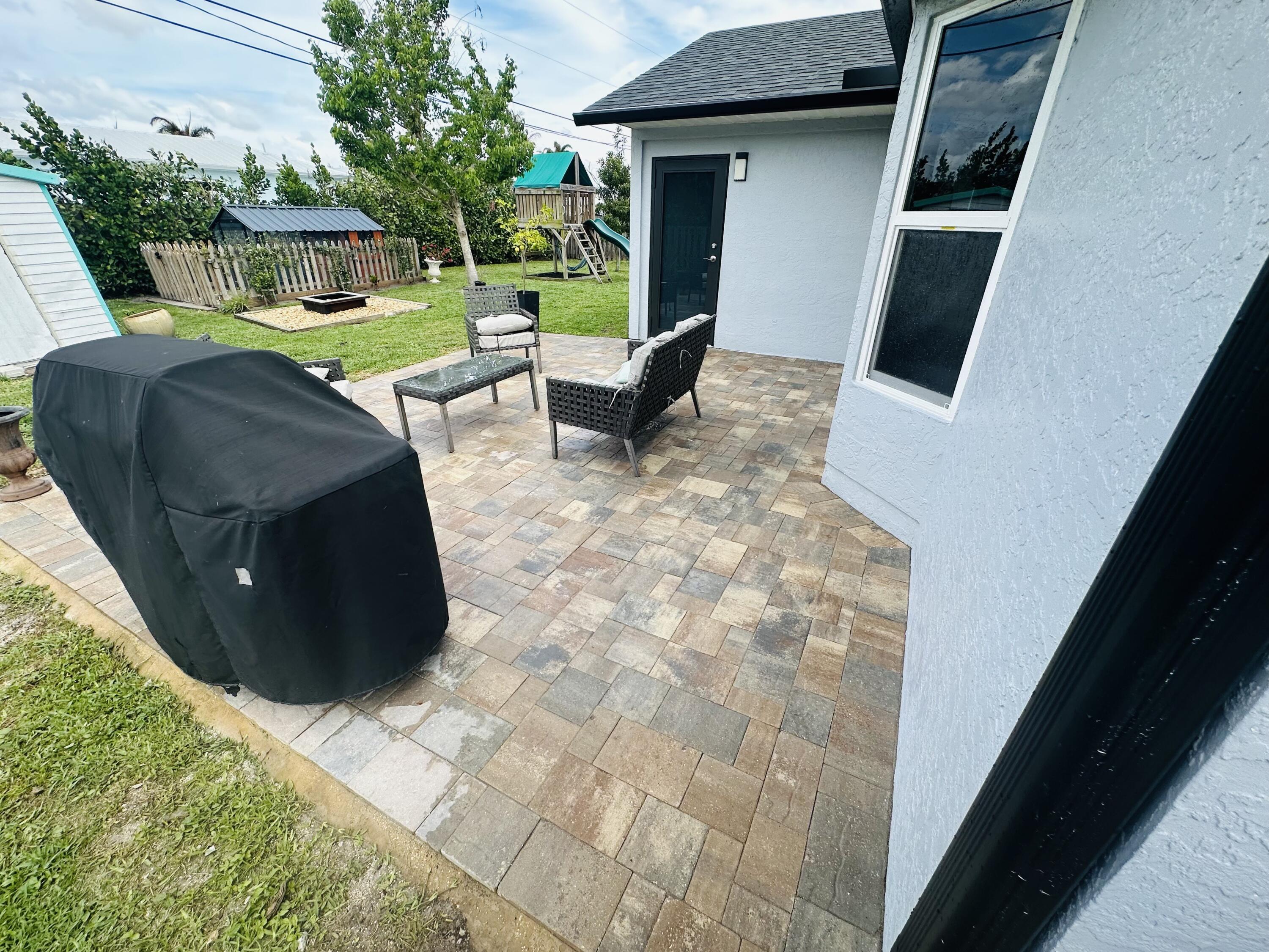 462 Southeast Cork Road Port St. Lucie, FL 34984 - Photo 34 of 57 a view of a patio with table and chairs a barbeque with wooden floor and potted plants