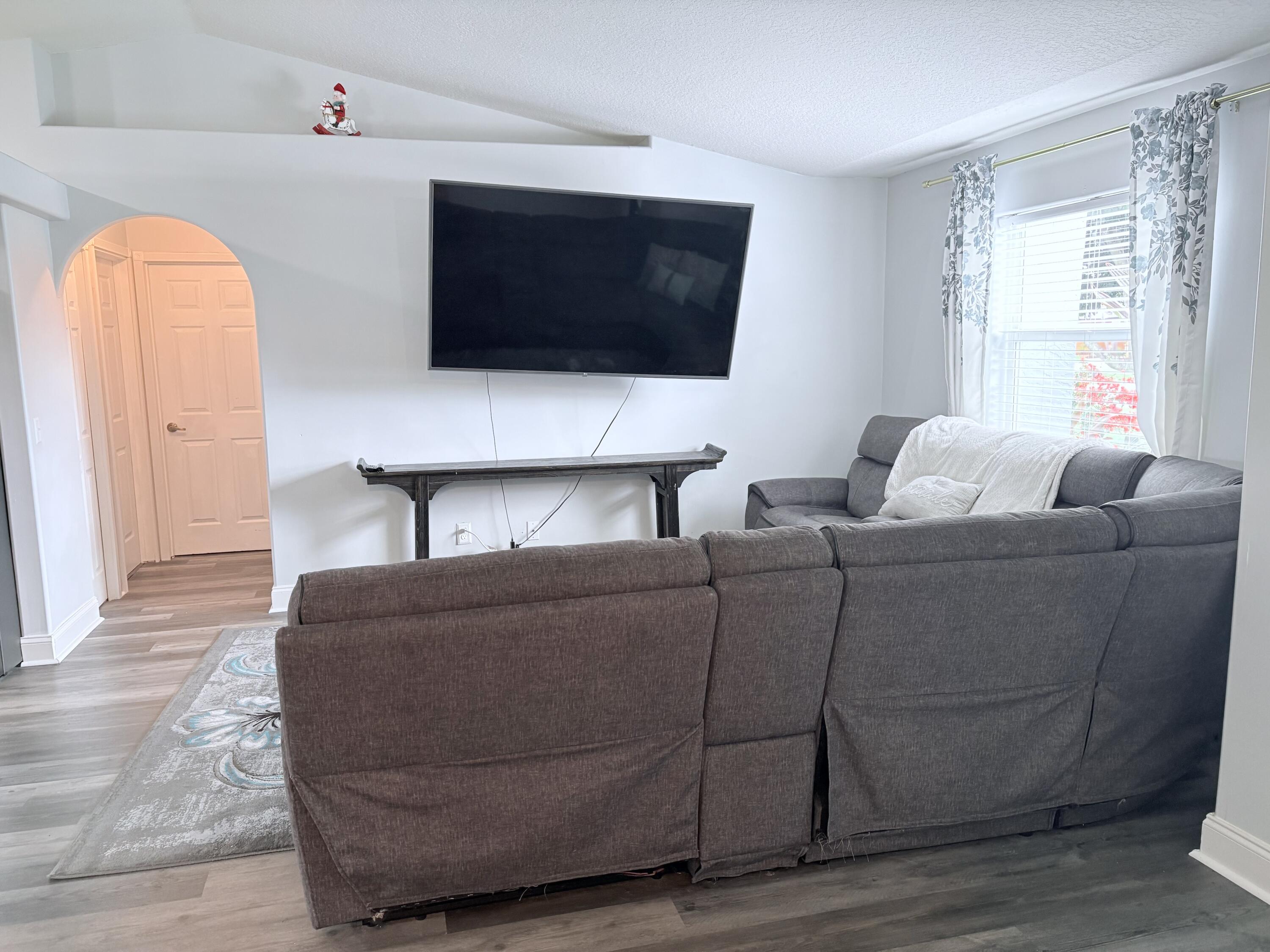 462 Southeast Cork Road Port St. Lucie, FL 34984 - Photo 37 of 57 a living room with furniture a flat screen tv and a window