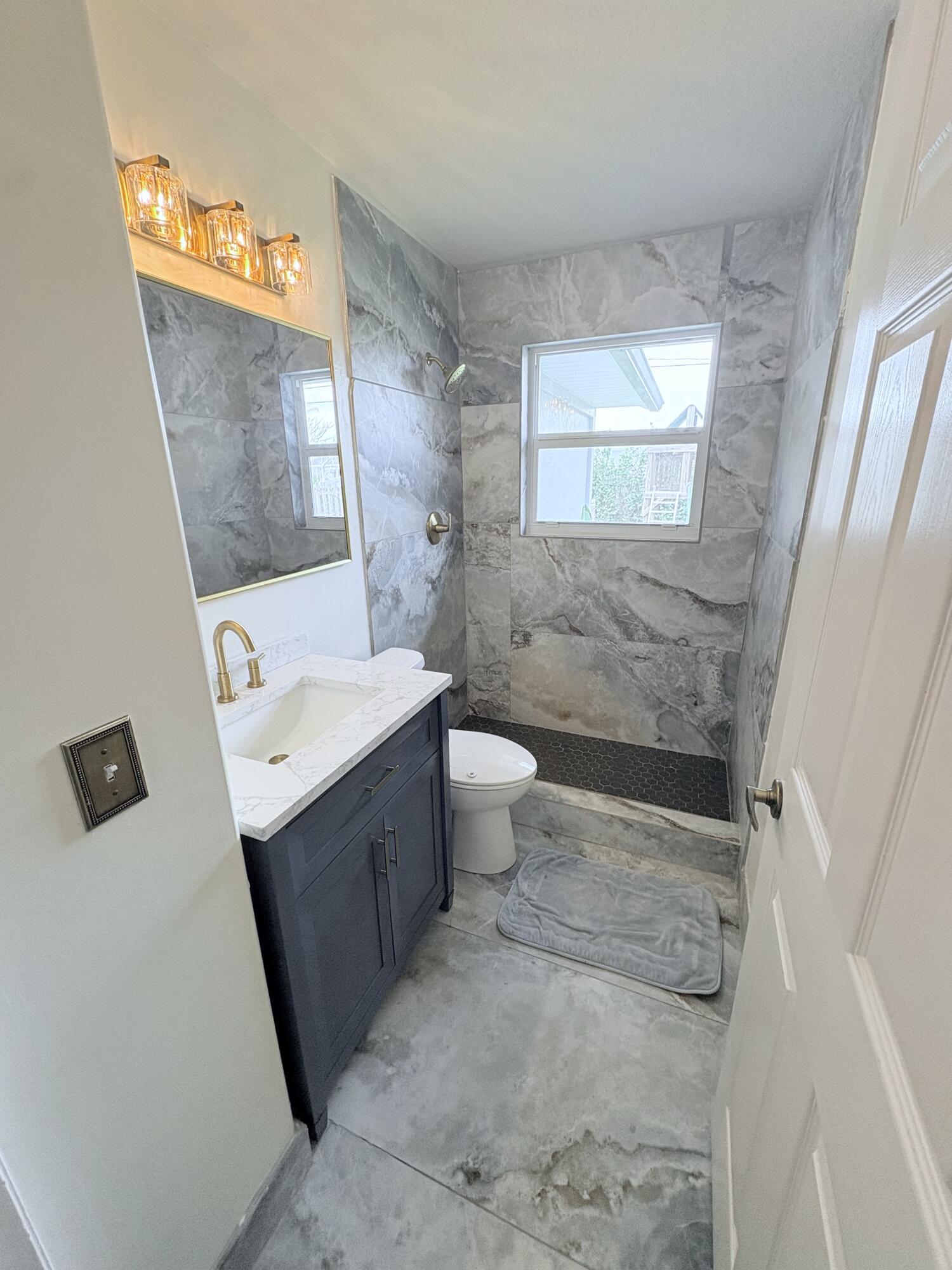 462 Southeast Cork Road Port St. Lucie, FL 34984 - Photo 38 of 57 a bathroom with a sink a toilet and mirror