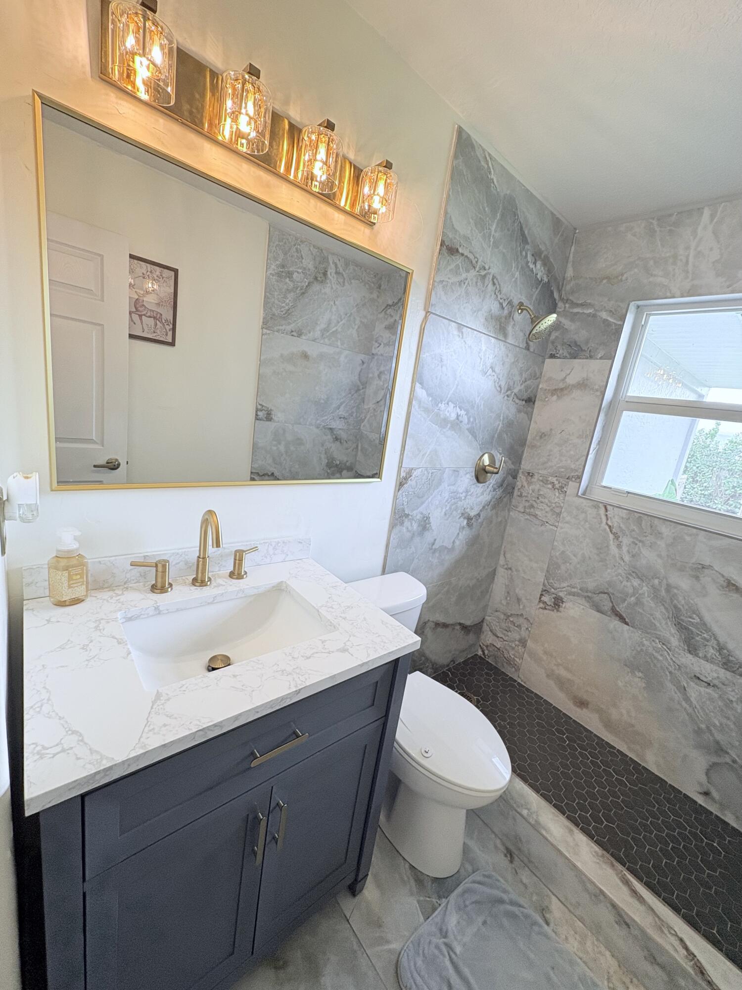 462 Southeast Cork Road Port St. Lucie, FL 34984 - Photo 39 of 57 a bathroom with a sink mirror vanity and toilet