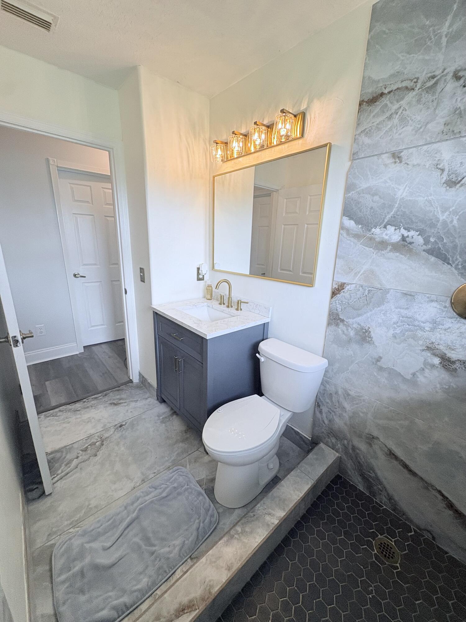 462 Southeast Cork Road Port St. Lucie, FL 34984 - Photo 40 of 57 a bathroom with a toilet sink and mirror