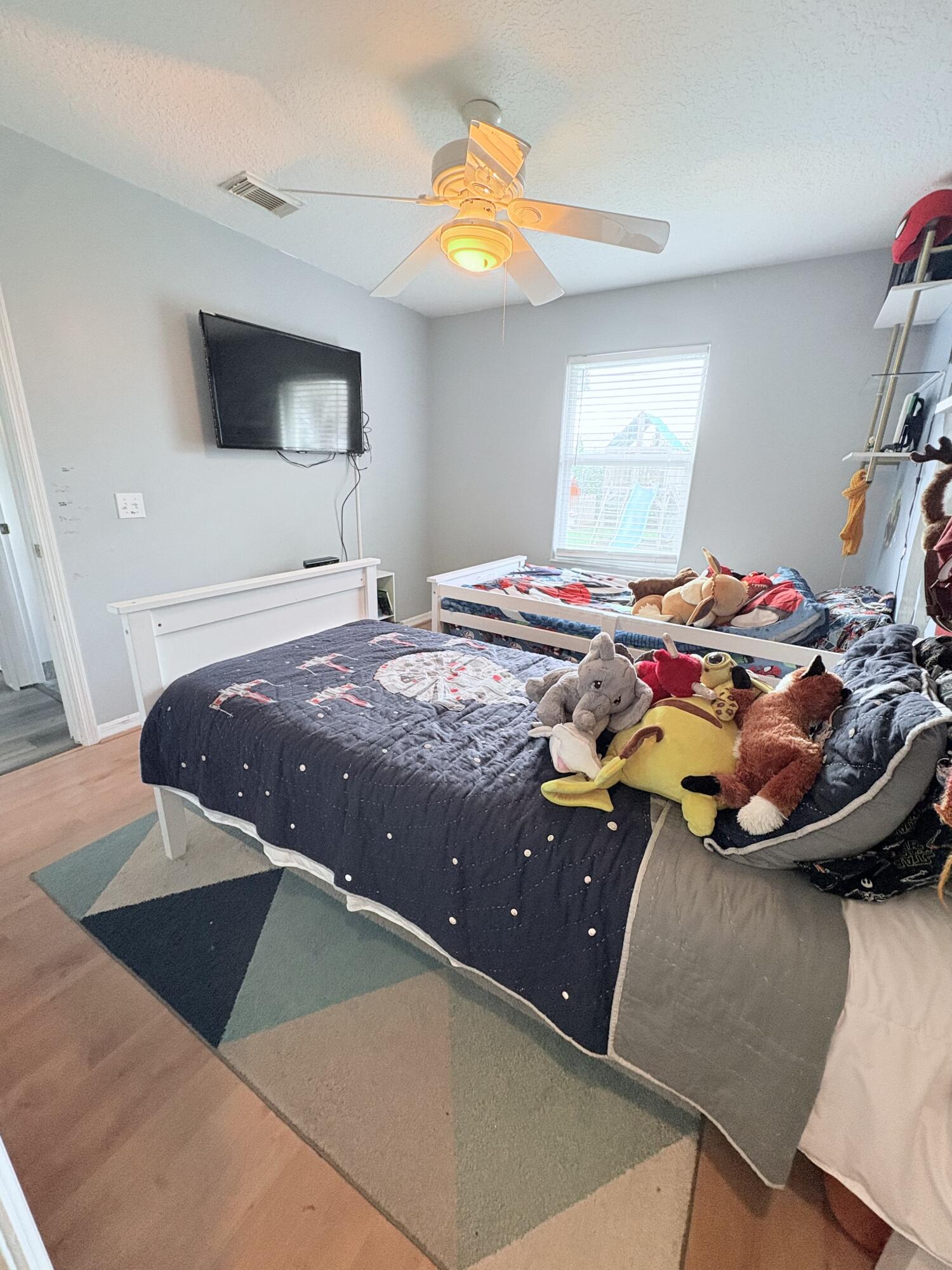 462 Southeast Cork Road Port St. Lucie, FL 34984 - Photo 49 of 57 a bedroom with a bed and a chandelier