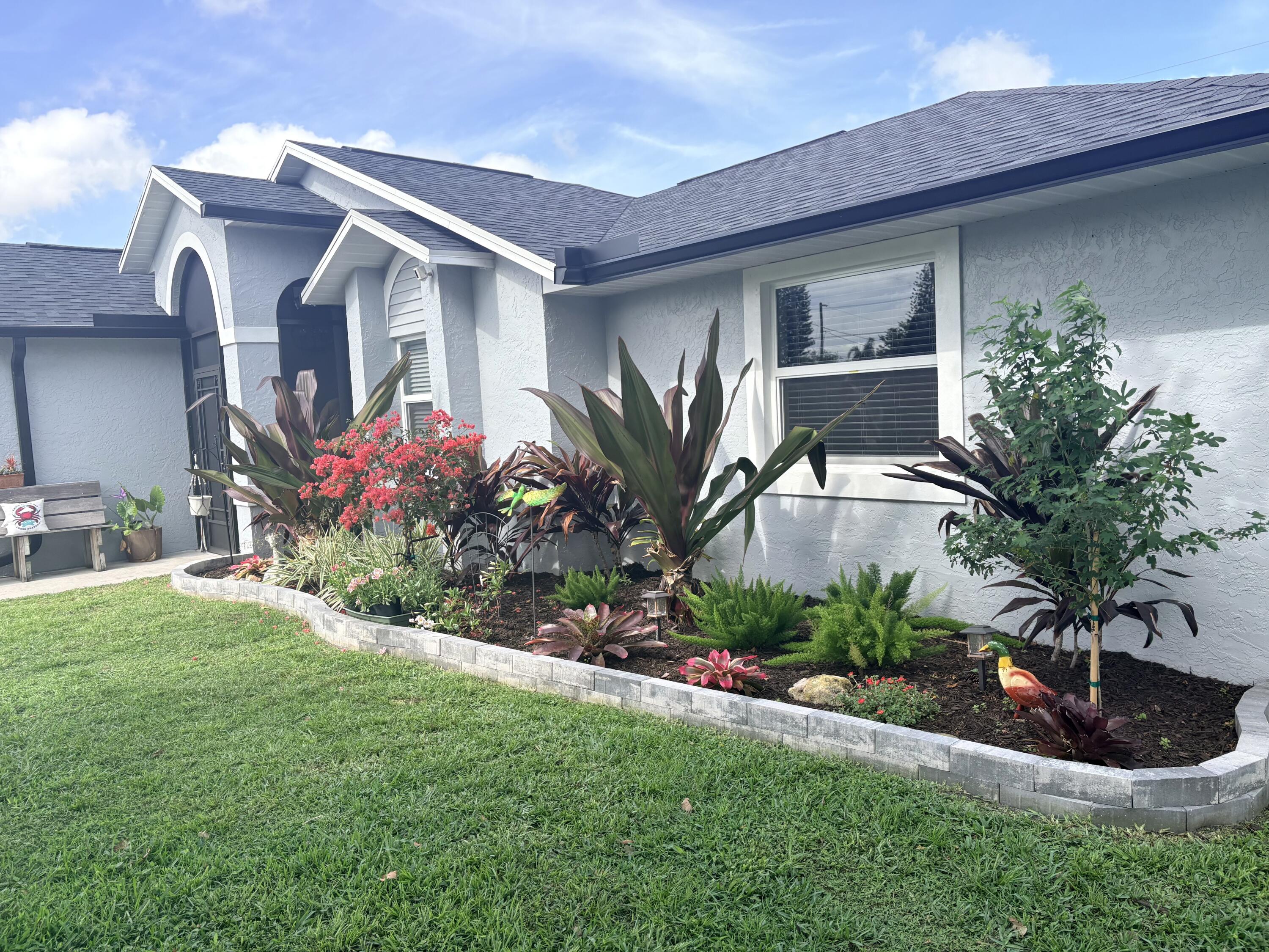 462 Southeast Cork Road Port St. Lucie, FL 34984 - Photo 5 of 57 a front view of a house with a garden