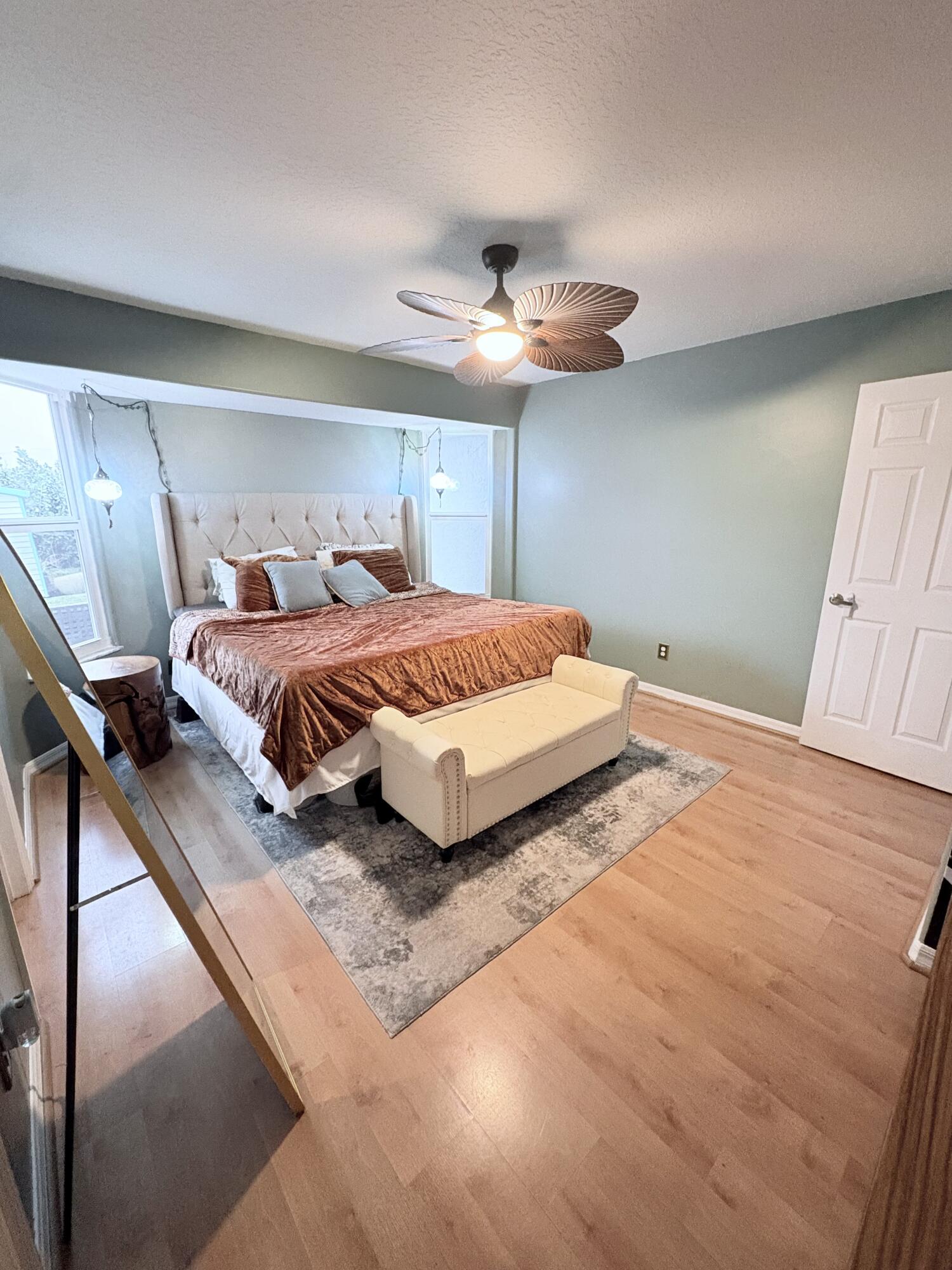 462 Southeast Cork Road Port St. Lucie, FL 34984 - Photo 55 of 57 a bedroom with a large bed and a chandelier