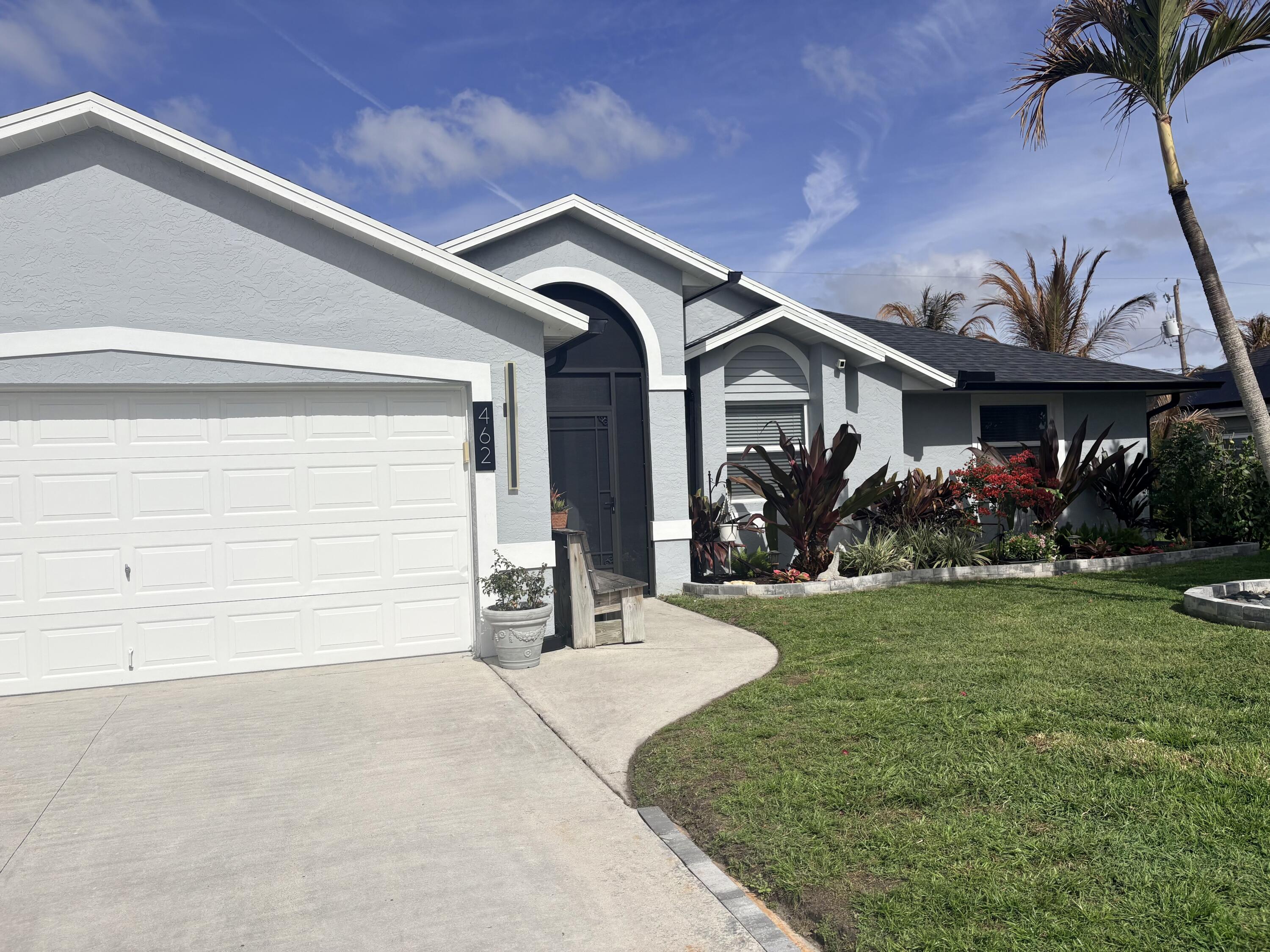 462 Southeast Cork Road Port St. Lucie, FL 34984 - Photo 8 of 57 a front view of a house with garden