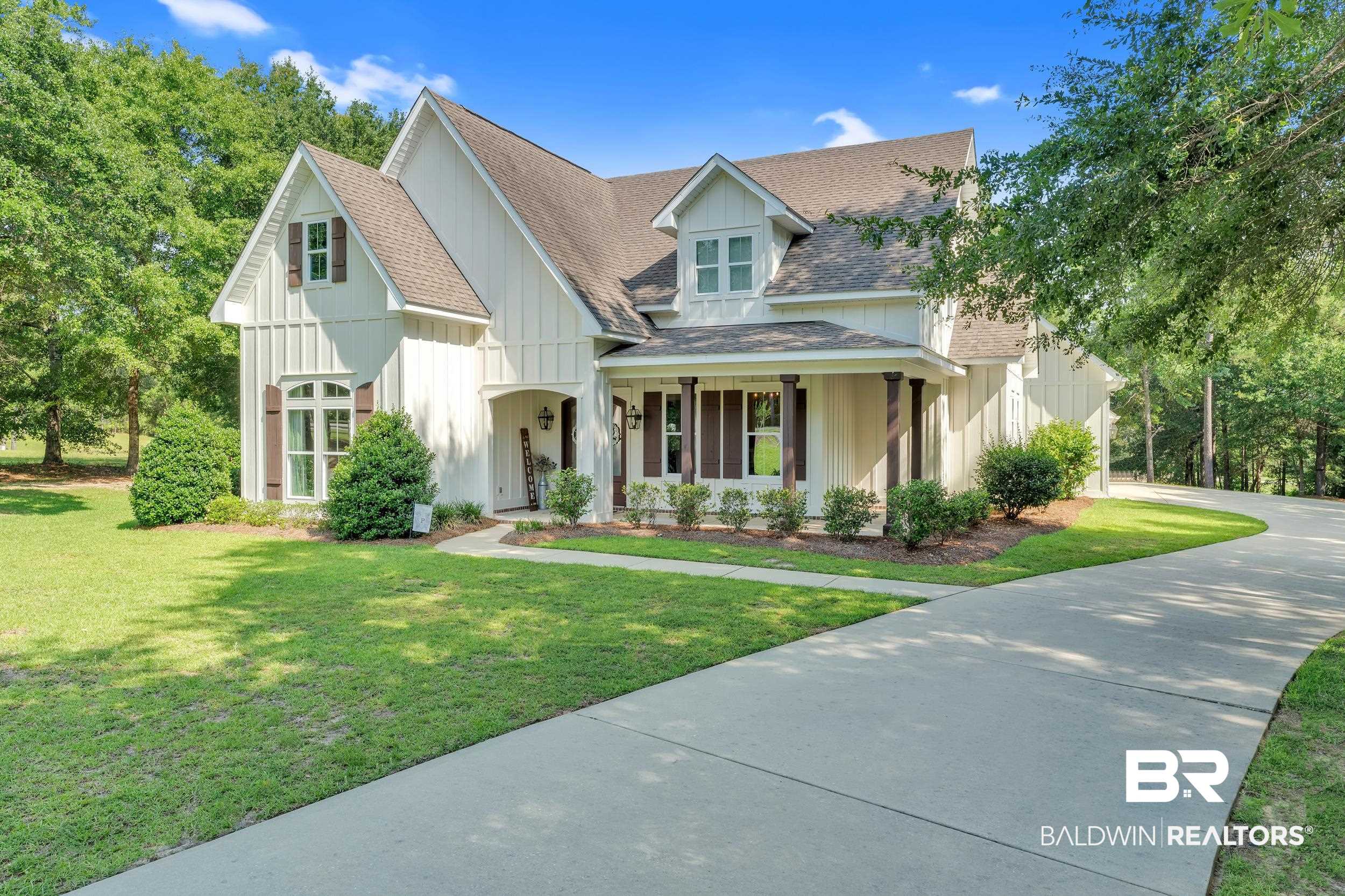 14531 Styx River Road Stapleton, AL 36578 - Photo 2 of 50 View of front of home with board and batten siding, a shingled roof, a front yard, concrete driveway, and a porch