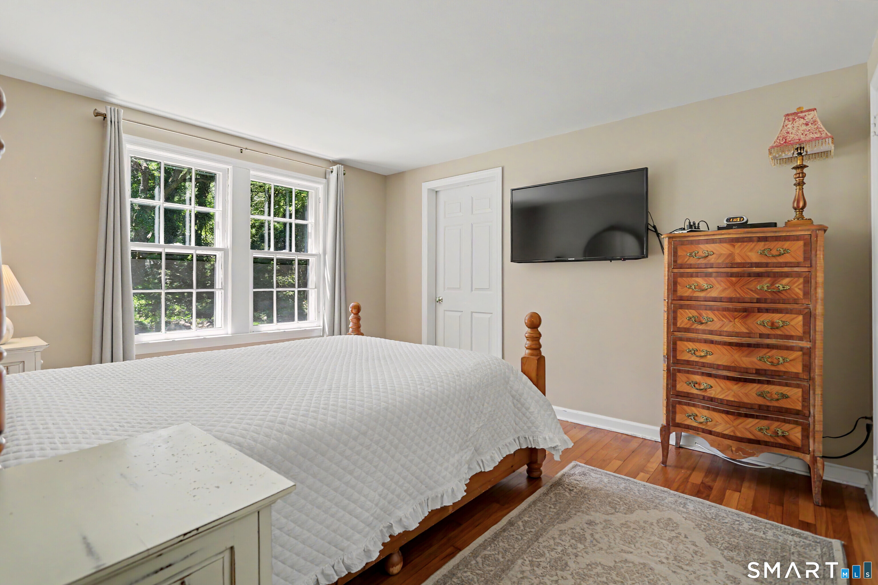 31 Vista Road Wilton, CT 06897 - Photo 13 of 34 Light-filled primary bedroom with hardwood floors and tranquil wooded views.