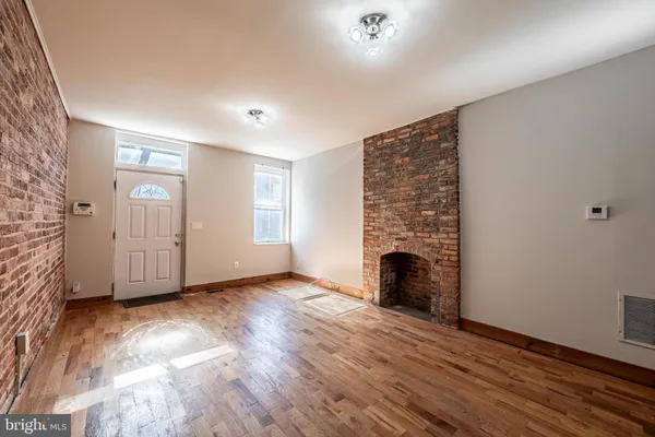wooden floor fireplace and windows in an empty room