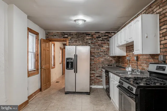 a kitchen with stainless steel appliances granite countertop a refrigerator a stove and a sink