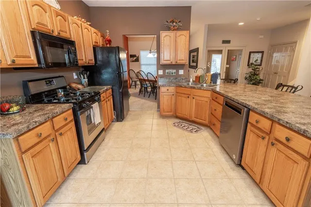 a large kitchen with stainless steel appliances granite countertop a stove a sink dishwasher and a refrigerator