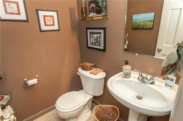 a bathroom with a toilet sink and mirror