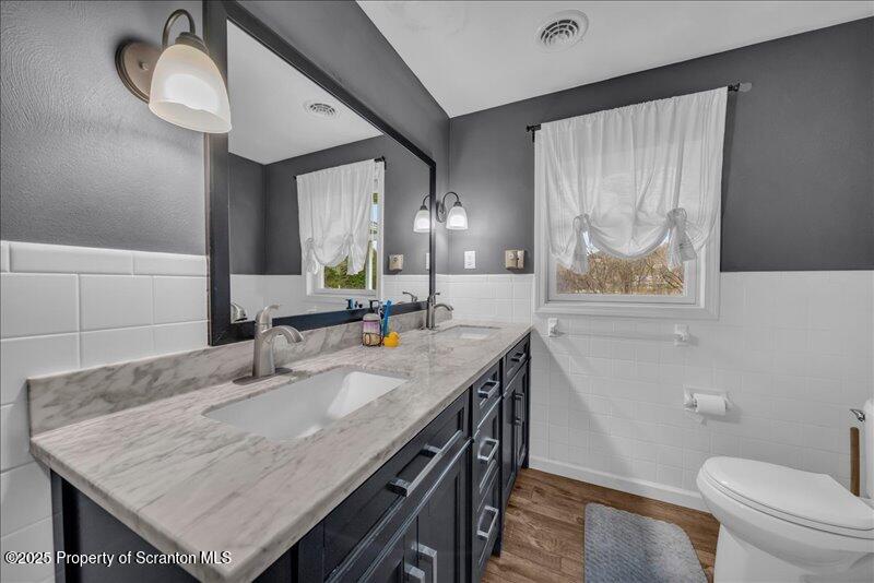 895 Cemetery Road Little Meadows, PA 18830 - Photo 24 of 40 a bathroom with a granite countertop sink a toilet a mirror and vanity