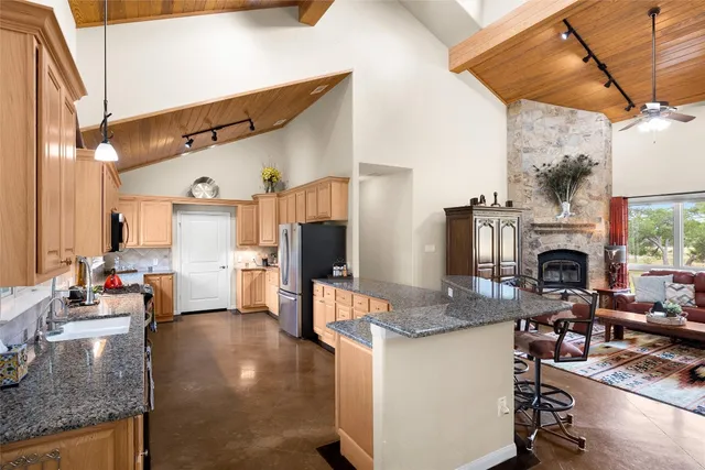 a kitchen with kitchen island granite countertop a table chairs stove and granite counter tops