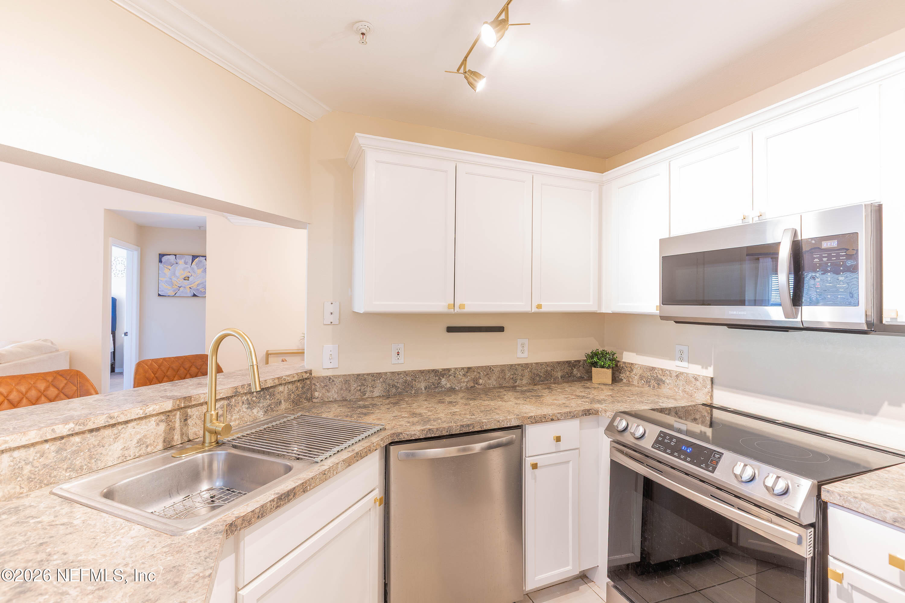 10961 Burnt Mill Road, Unit 734 Jacksonville, FL 32256 - Photo 7 of 35 a kitchen with granite countertop a sink and a stove top oven