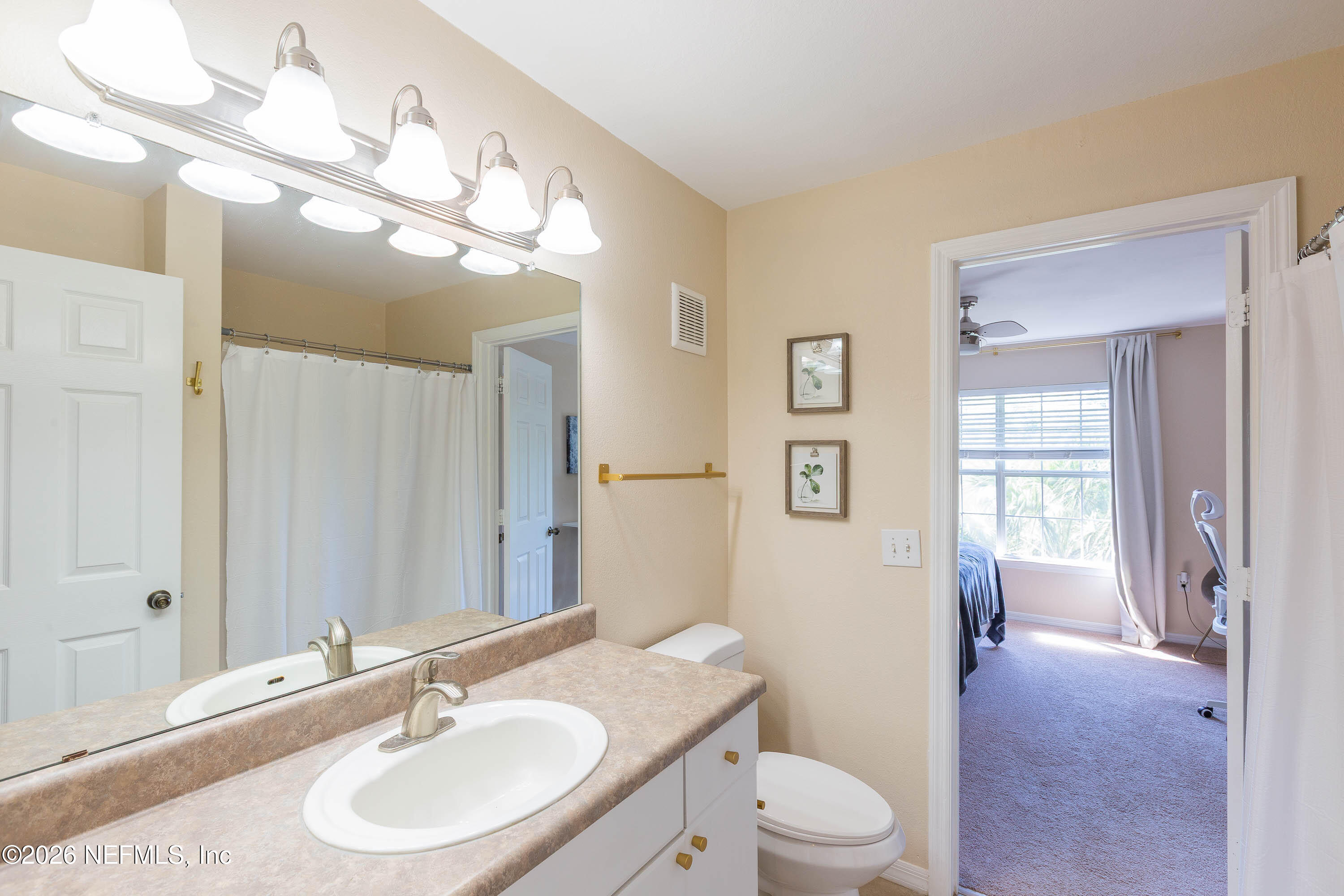 10961 Burnt Mill Road, Unit 734 Jacksonville, FL 32256 - Photo 9 of 35 a bathroom with a toilet a sink a mirror a vanity and window