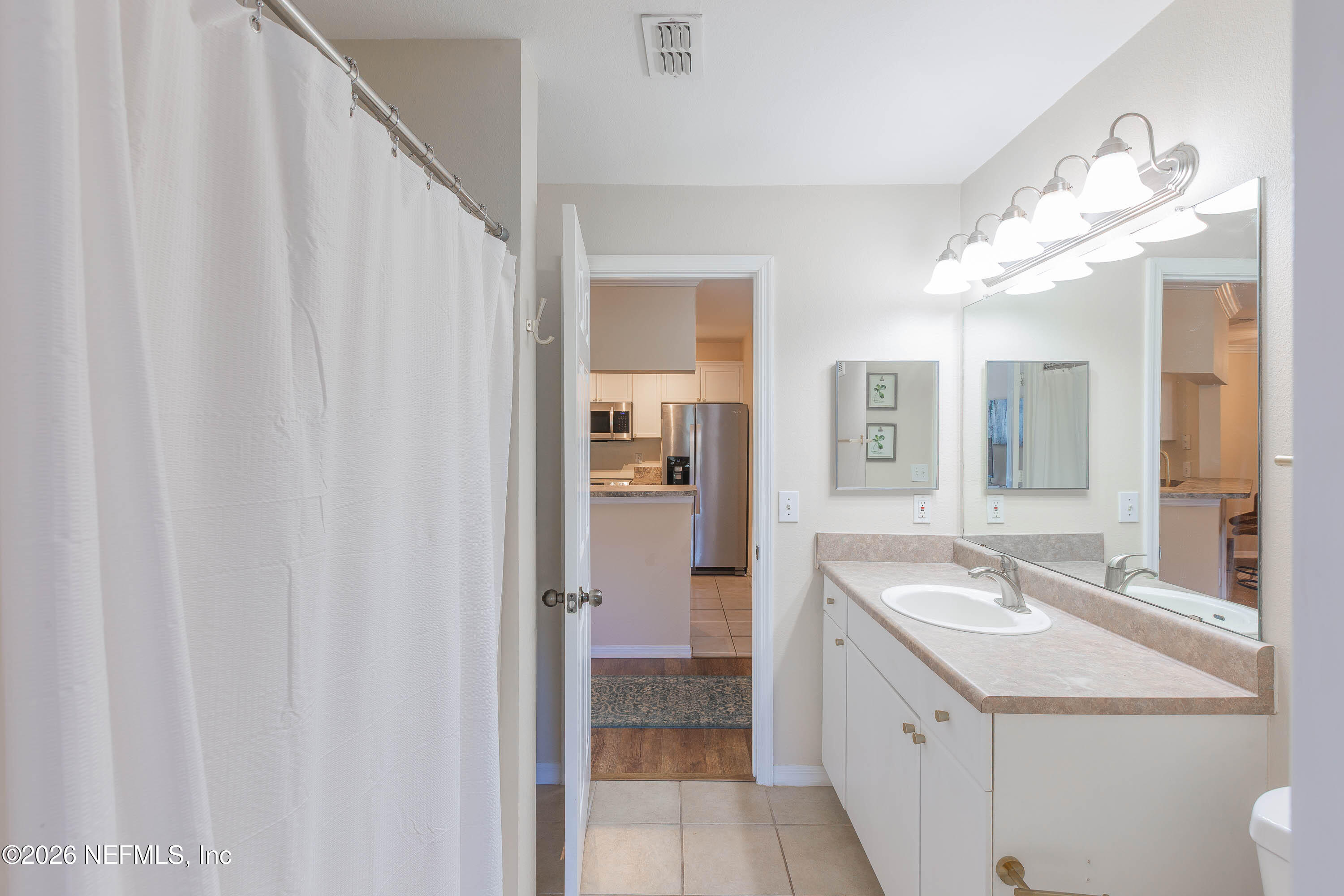 10961 Burnt Mill Road, Unit 734 Jacksonville, FL 32256 - Photo 10 of 35 a bathroom with a sink a mirror and a shower
