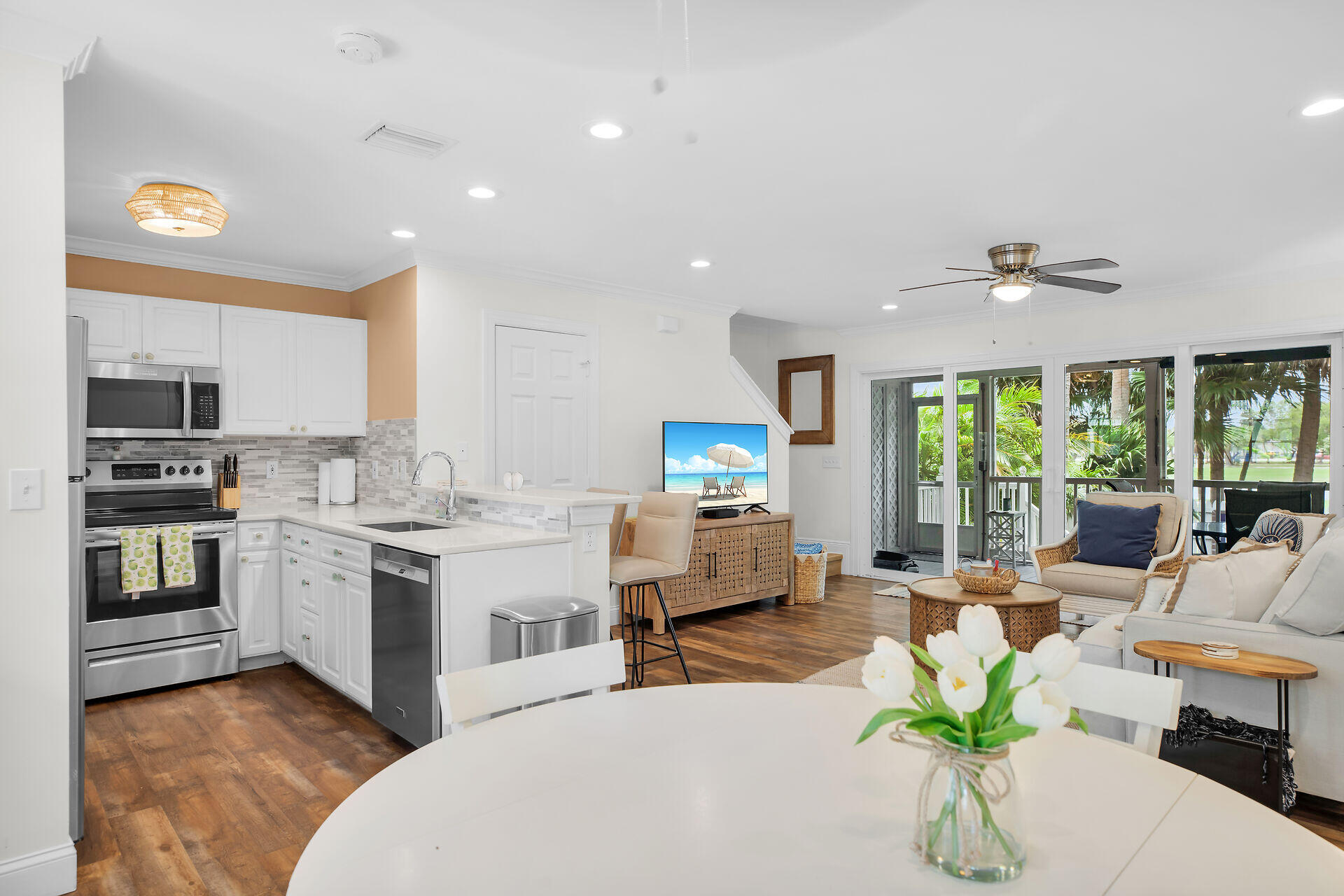 60 Golf Club Drive Key West, FL 33040 - Photo 7 of 42 a living room with stainless steel appliances kitchen island granite countertop a stove a sink a dining table and chairs with wooden floor
