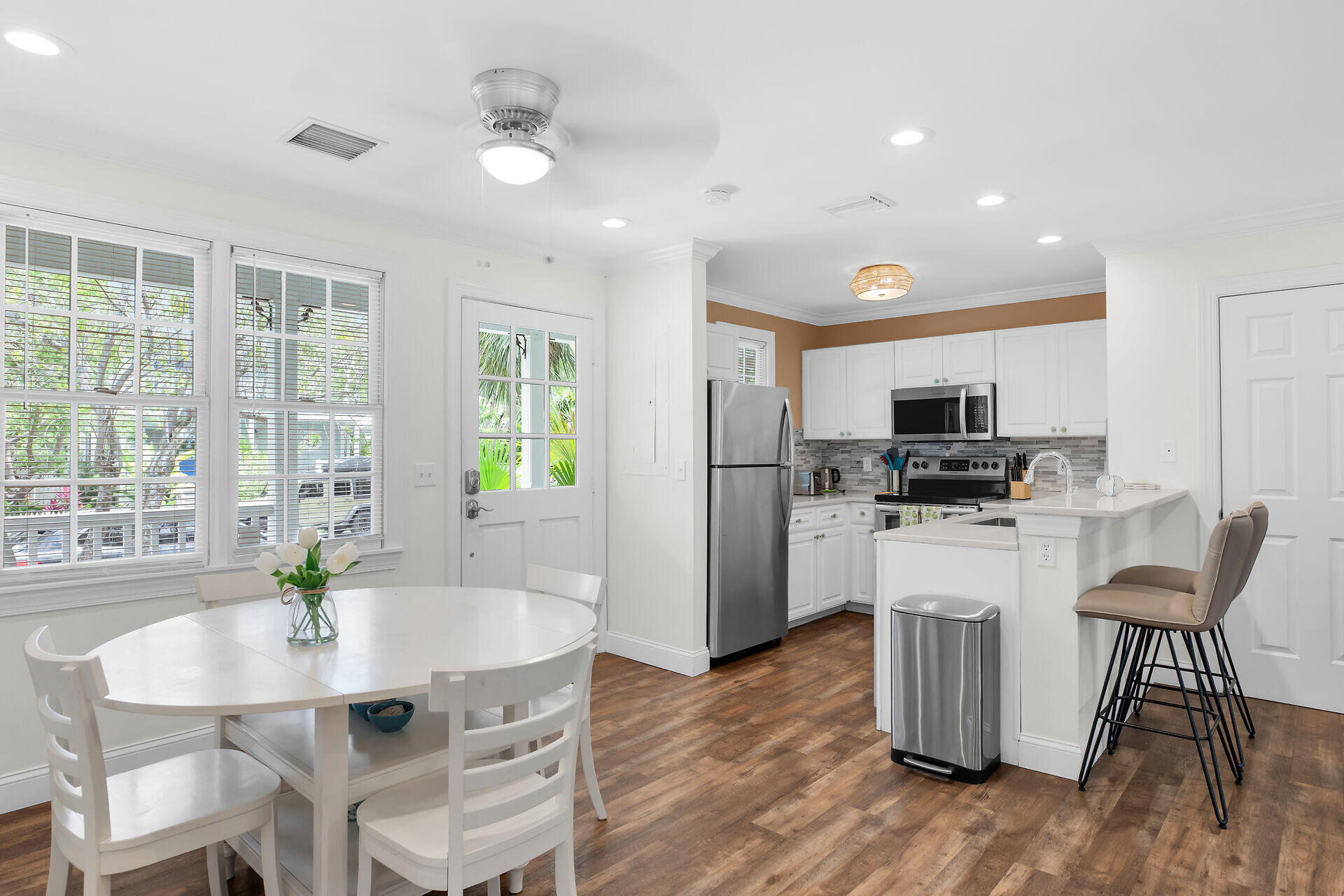 60 Golf Club Drive Key West, FL 33040 - Photo 8 of 42 a kitchen with stainless steel appliances granite countertop a dining table chairs refrigerator and microwave