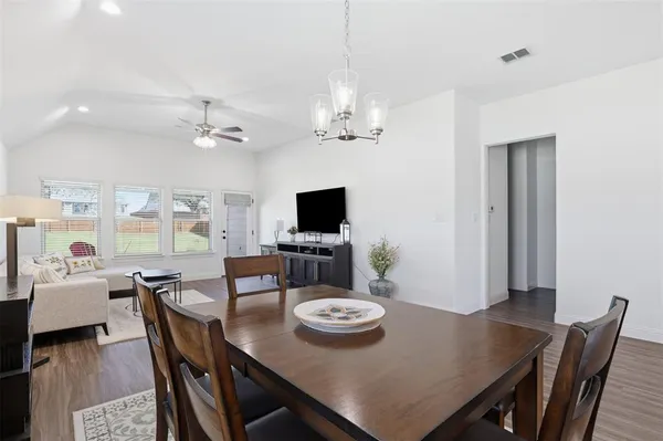 a view of a dining room with furniture a chandelier and wooden floor