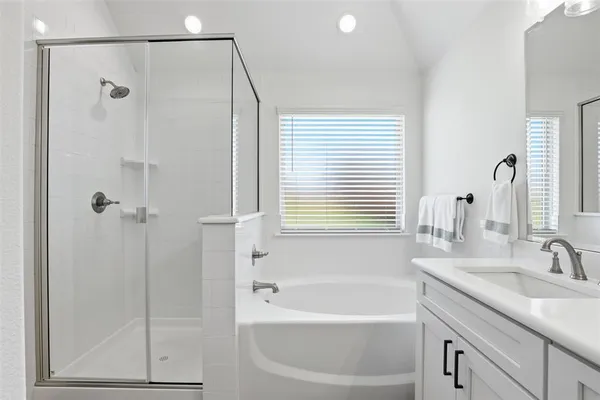 a bathroom with a granite countertop sink a mirror a shower and a bathtub