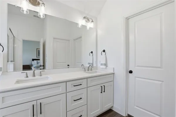 a bathroom with a double vanity sink and a mirror