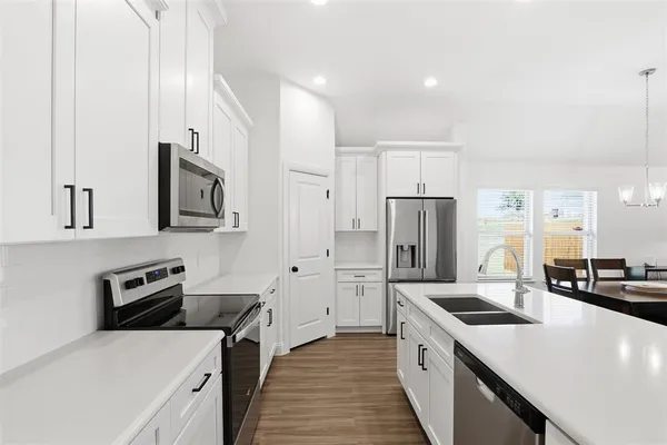 a kitchen with stainless steel appliances a refrigerator sink and stove
