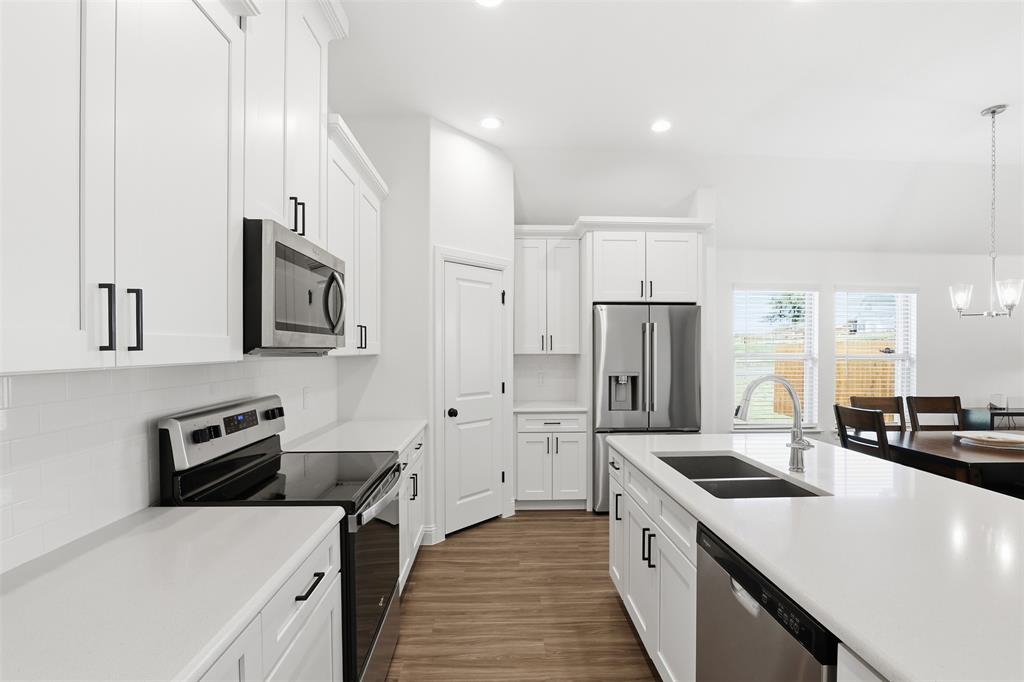 1101 Springfield Road Springtown, TX 76082 - Photo 9 of 32 a kitchen with stainless steel appliances a refrigerator sink and stove
