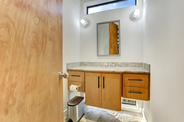 a bathroom with a granite countertop sink and a mirror