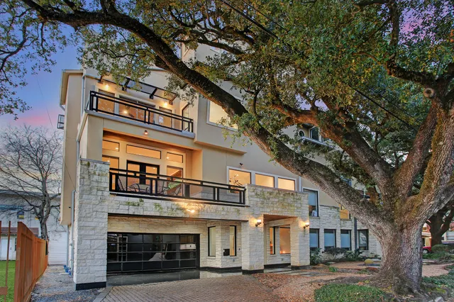 a front view of a house with a tree