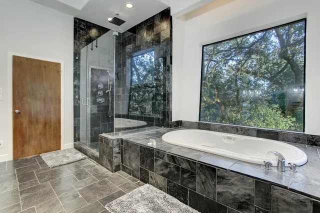 a spacious bathroom with a granite countertop tub sink and mirror