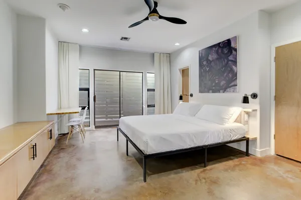 a spacious bedroom with a bed and a chandelier