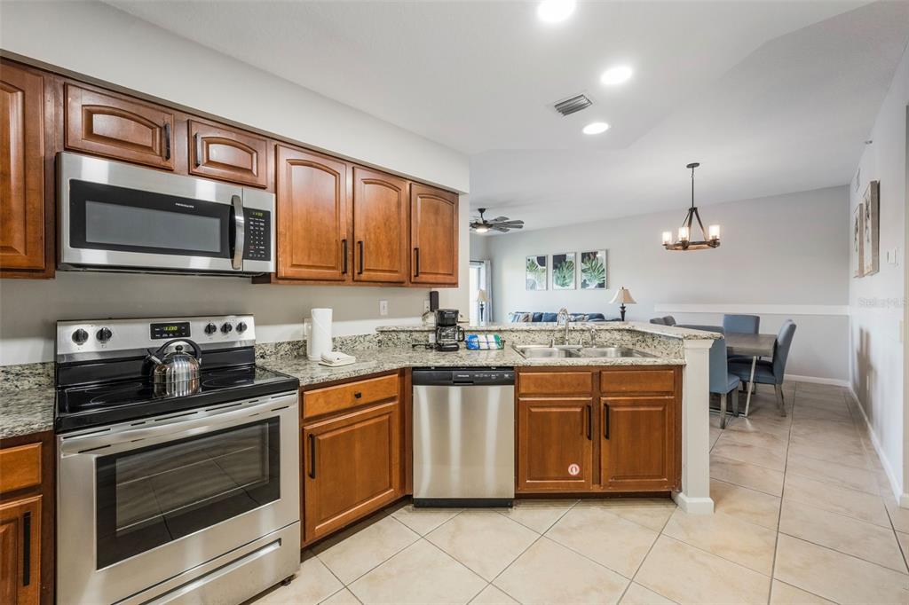 8774 Worldquest Boulevard, Unit 7404 Orlando, FL 32821 - Photo 13 of 55 a kitchen with stainless steel appliances granite countertop a stove microwave and cabinets
