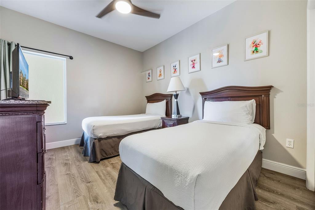 8774 Worldquest Boulevard, Unit 7404 Orlando, FL 32821 - Photo 17 of 55 a bedroom with two beds and a chandelier