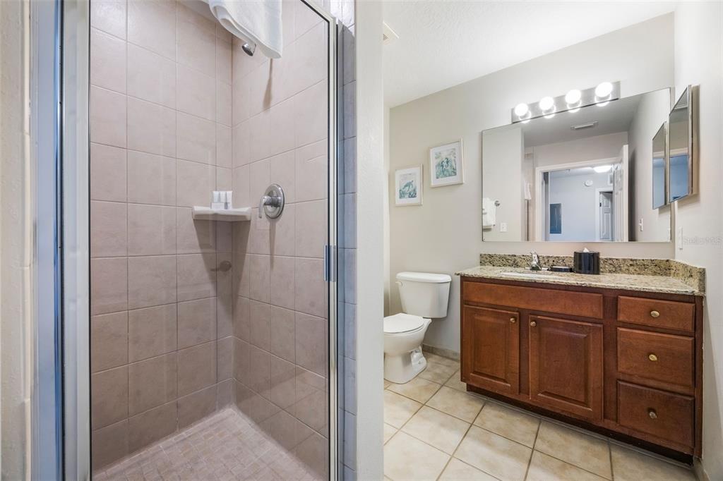 8774 Worldquest Boulevard, Unit 7404 Orlando, FL 32821 - Photo 23 of 55 a bathroom with a granite countertop sink toilet and shower