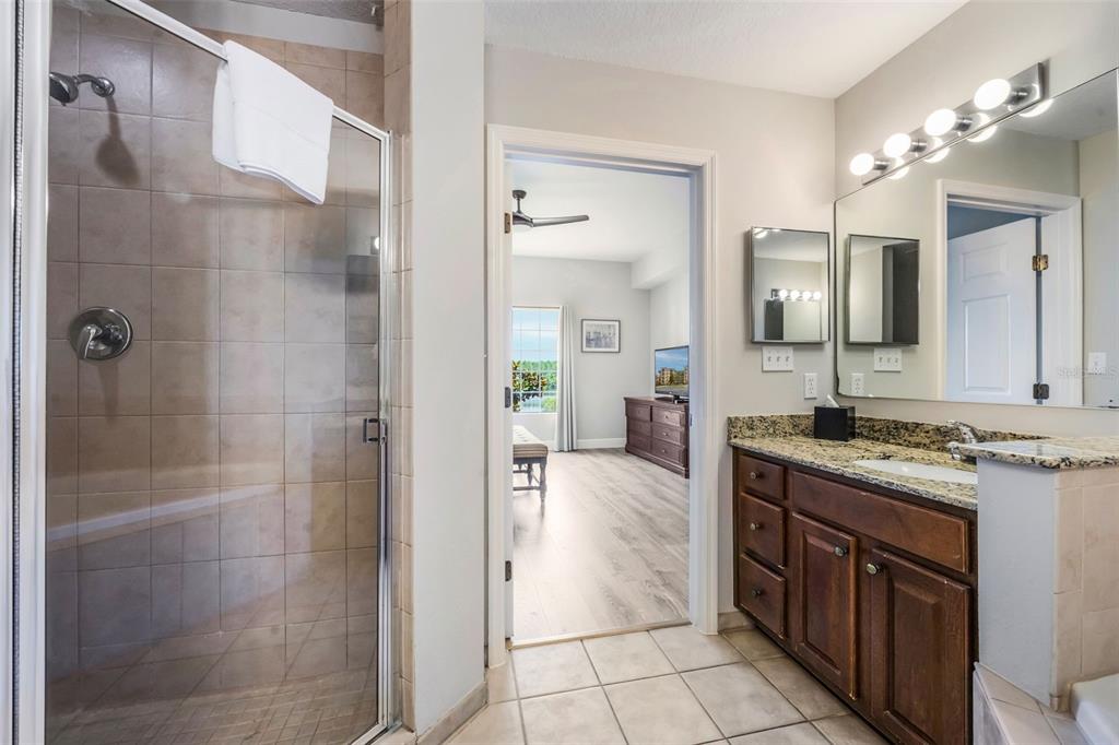 8774 Worldquest Boulevard, Unit 7404 Orlando, FL 32821 - Photo 25 of 55 a spacious bathroom with a granite countertop sink mirror and shower