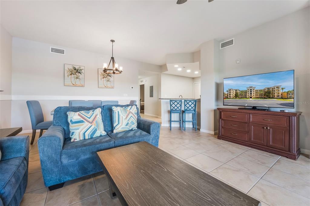 8774 Worldquest Boulevard, Unit 7404 Orlando, FL 32821 - Photo 7 of 55 a living room with furniture and a wooden floor