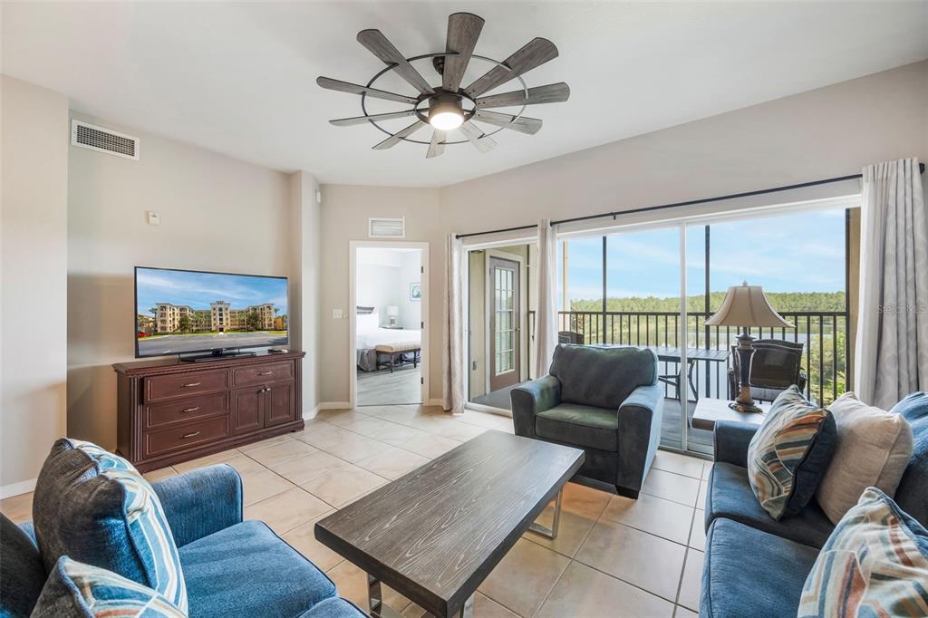8774 Worldquest Boulevard, Unit 7404 Orlando, FL 32821 - Photo 8 of 55 a living room with furniture and a floor to ceiling window