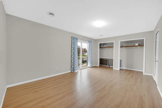 an empty room with wooden floor and fireplace