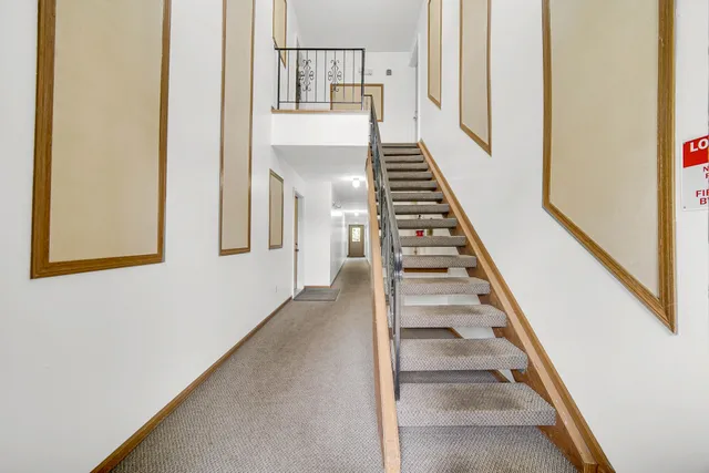 a view of staircase with wooden floor and white walls