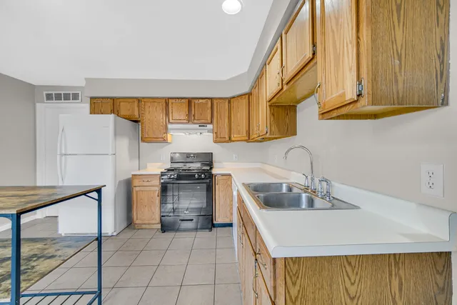 a kitchen with sink cabinets and stove top oven