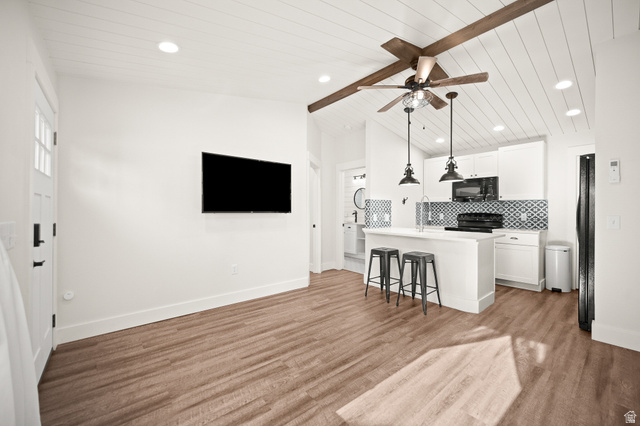 236 West 300 South Hurricane, UT 84737 - Photo 50 of 76 Open-concept living space featuring wood-finish flooring, a vaulted shiplap ceiling with exposed wood beams, and a ceiling fan