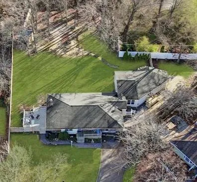 an aerial view of a house with a yard basket ball court and outdoor seating