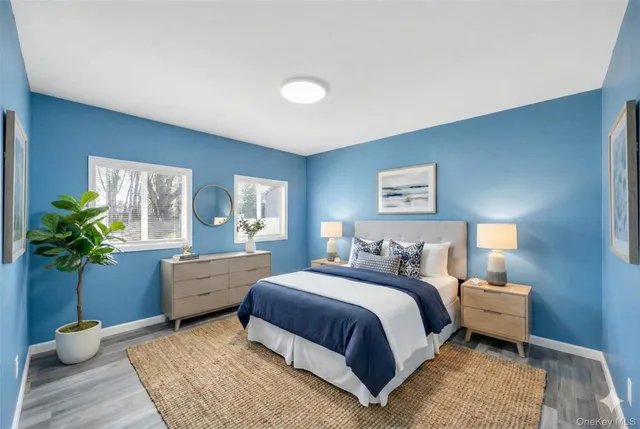 a bedroom with a two bed potted plant and a window